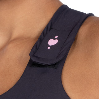 Front view of black Serena Bra for post-surgery recovery, showing close-up of adjustable strap fastened in place.