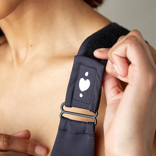 Front view of black Shirl Post-Surgical Bra for heart surgery and other procedures limiting mobility, showing adjustable strap with Velcro for easy use.