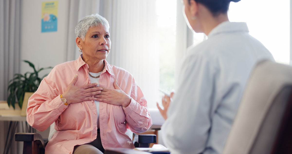 A woman talking to her doctor. Preparing for open-heart surgery? Here's what to know about compression bra timelines, sternal healing, and choosing the right garment in advance