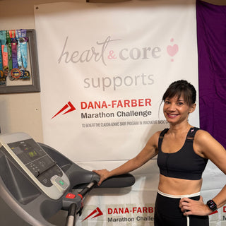 Amber trains next to the heart&core supports Dana-Farber banner while wearing a heart&core Shirl Bra.