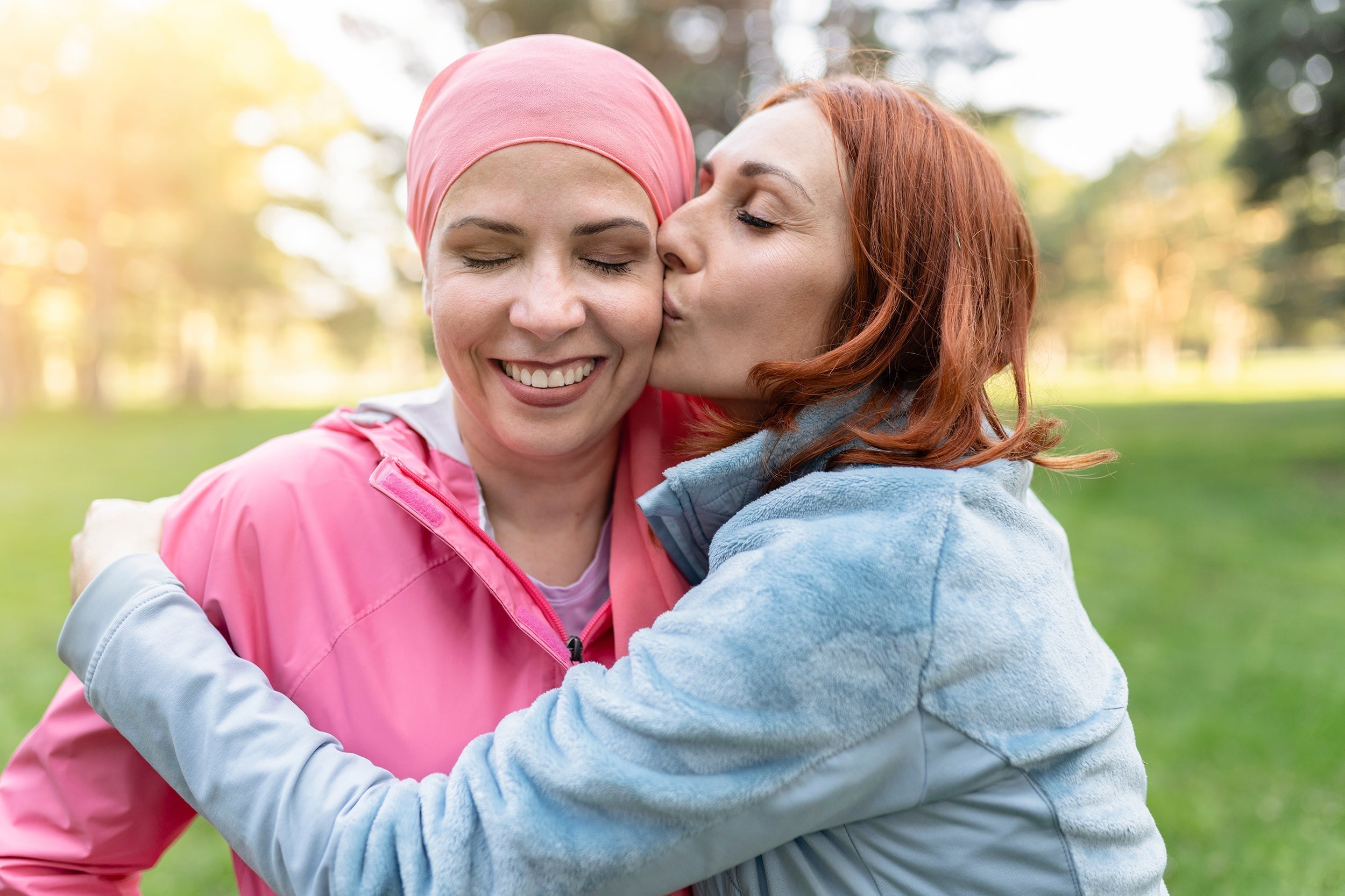 A woman plants a kiss on her loved one who has breast cancer. In the complex journey of breast cancer treatment and recovery, small comforts make monumental differences, namely a really great reconstructive surgery bra.